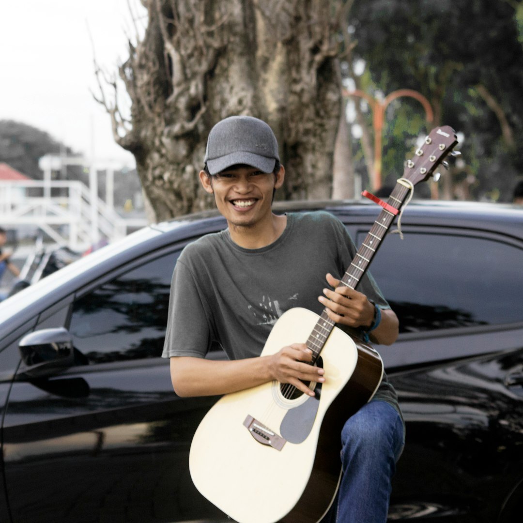 Portrait of a young musician holding an acoustic guitar