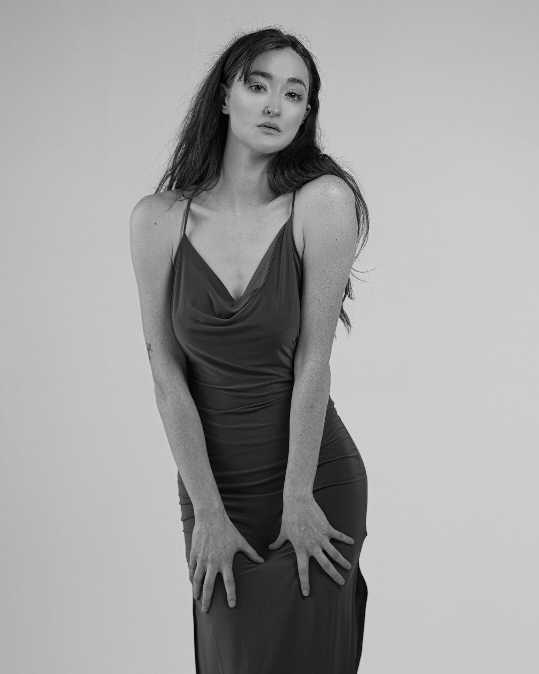 Fashion model wearing a flowing burgundy dress in a studio