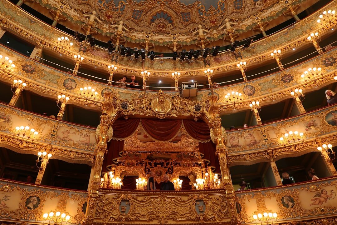 Grand ornate theater interior with red seats and gilded balconies