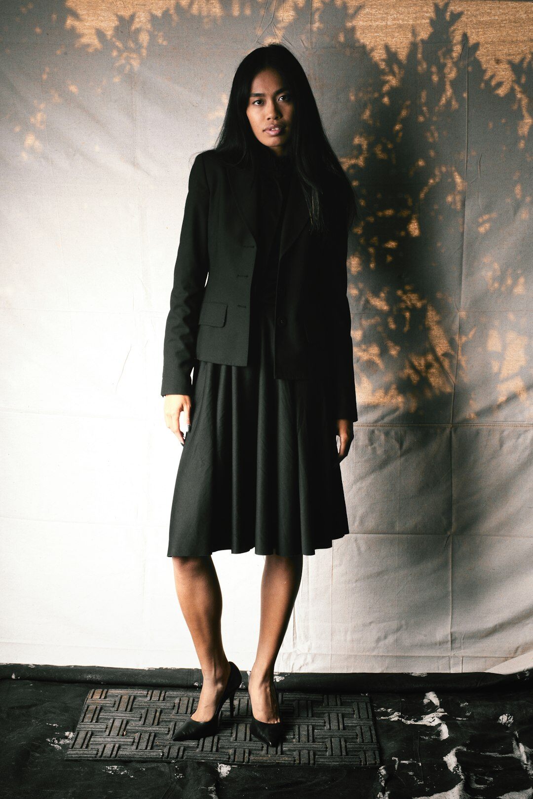 Woman in a structured dark suit walking confidently at an event