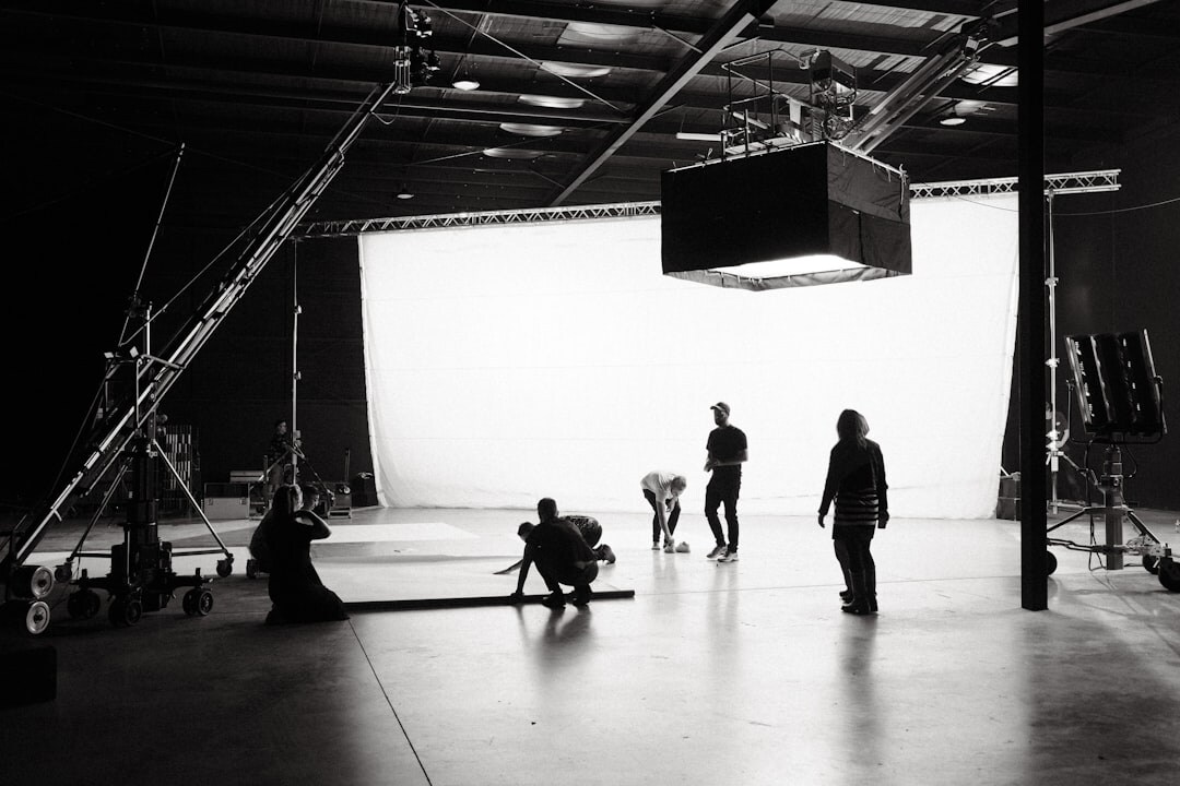 Crew members working behind the scenes with lighting equipment on a set