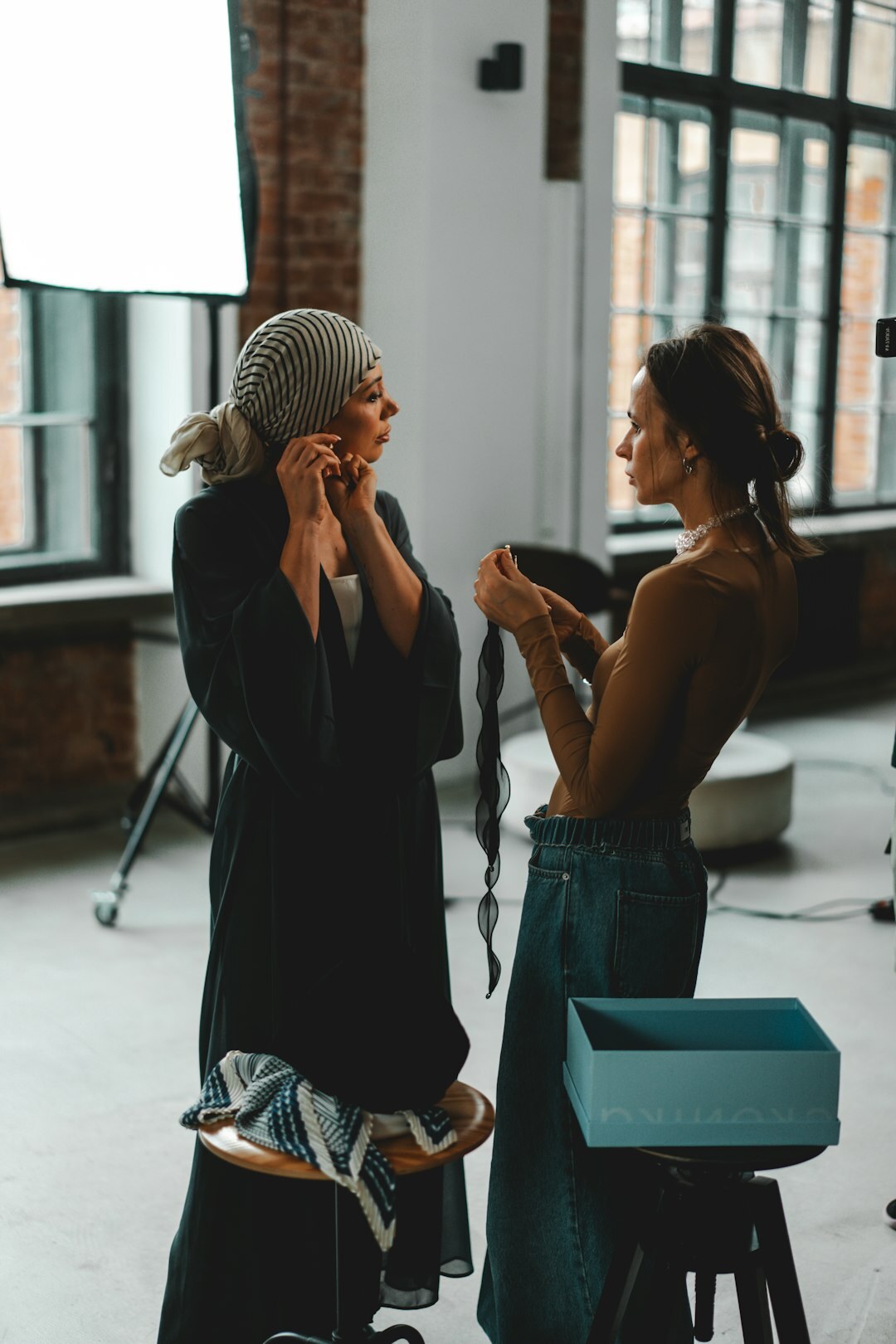 Candid backstage moment of a woman being prepared before a show